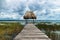 Hut with straw roof at the dock along the lake shore with dark blue cloudscape, El Remate, Peten, Guatemala