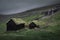 Huts with a grass roof and waterfall in Saksun village on Streymoy Island, Faroe Islands