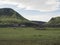 Hvanngil campsite path in lava field and green valley, small houses of hvanngil hut. volcanic mountains volcanic