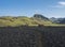 Hvanngil campsite path in lava field and green valley, small houses of hvanngil hut. volcanic mountains volcanic