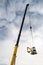 Hydraulic crane telescopic boom detail moving a track excavator on cloudy sky background