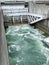 Hydro dam control weir with underneath discharge