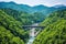 hydroelectric dam against forested mountain backdrop