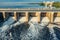 Hydroelectric dam or hydro power station at water reservoir, aerial view from drone. Draining water through gate