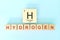 Hydrogen chemical element symbol with atomic mass and atomic number in wooden blocks flat lay composition.