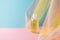 Hydrophilic cleanser oil on blue pink background with colorful rainbow organza fabric drapery. Makeup remover mockup