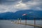 Hydroplane tied to the water aerodrome and the wind blowing into a windsock over blue and cloudy sky