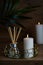 hygge and aromatherapy concept - burning candles and aroma diffuser on table at home