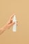 Hygiene. Bottle Of Antiseptic Spray In Caucasian Female Hand On Beige Background. Daily Personal Hygiene Routine
