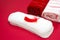 Hygiene concept photo. Bath terry towels, red feather on the heap of menstrual woman pads for blood period. Menstruation sanitary