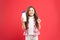 Hygiene habits for kids. Happy little girl holding gel or shampoo bottle for personal hygiene on red background. Small