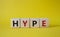 Hype symbol. Concept word Hype on wooden cubes. Beautiful yellow background. Business and Hype concept. Copy space