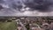 Hyper lapse aerial view of town under thunderstorm clouds