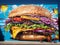 Hyper-Realistic Hunger: Oversized Cheeseburger & Fries Mural in Urban Delight