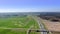 Hyperlaps over the highway with cars on top of the background of green fields and forests.