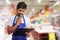 Hypermarket employee thinking with clipboard in hand