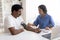 Hypertension. Indian Doctor Woman Measuring Blood Pressure Of Male Patient In Clinic