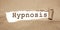Hypnosis word appearing behind torn brown paper. Reduce stress psychological healthcare concept
