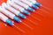 Hypodermic syringe. Syringes with blue needles on a red background. Medical Injectors.