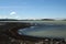 HÃ¡lslÃ³n lake with black volcanic beach and snow capped mountains in Iceland