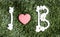 I and B letters and three paper heart cut outs on grass.