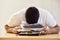 I cant cope with all of this work. an unrecognisable man asleep on a stack of paperwork while working from home.