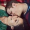 I could kiss these cheeks all day. an affectionate young couple relaxing together on a picnic blanket.