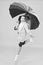 I do not care. Carefree schoolgirl jumping with umbrella waterproof rain coat. Autumn rain. Rainy days bright