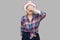 I don`t want to see it. Portrait of scared or shocked modern stylish mature woman in casual style in white hat standing and close