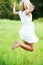 I feel great. Beautiful young woman jumping while in a field outdoors.