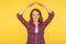 I feel safe! Portrait of happy secured ginger girl in checkered shirt showing roof gesture over head and smiling, house insurance