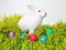 I found treasure. Studio shot of a cute rabbit on the grass with an assortment of brightly colored eggs.