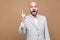 I have idea. Portrait of handsome amazed middle aged bald bearded businessman in classic gray suit standing with finger up and lo