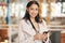 I have something that I have to share with you. a young woman using her smartphone to send a text while shopping.