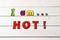 I am hot! Positive affirmation, statement. Bold neon letters on white washed wood table