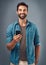 I keep my lifestyle mobile. Studio shot of a handsome young man using a mobile phone against a grey background.