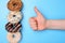 I like donut in restaurant positive reaction concept. Close up photo of tasty donuts and people rising thumb up isolated over