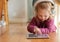 I listen and then repeat the words perfectly. an adorable little girl wearing headphones whiles using a digital tablet.