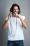 I love capturing the beauty of this world. Studio portrait of a young man posing with a vintage camera against a grey