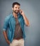 I love hearing your voice. Studio shot of a handsome young man using a mobile phone against a grey background.