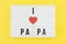 I love papa text on white lightbox with wooden heart on yellow background