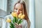 I love spring and flowers. Portrait of beautiful woman with bouquet of yellow tulips. Beauty and tenderness concept