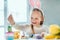 I love to paint Easter eggs!Little girl in rabbit ears paints Easter eggs