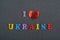 I love UKRAINE word on black board background composed from colorful abc alphabet block wooden letters, copy space for