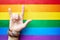 `I love you` in American sign language ASL which shows a man`s hand on the background of the flag of LGBT LGBTQ community