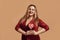 I love you. Plus size happy woman in velour dress holding a red heart-shaped lollipop and looking at camera with smile