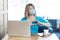 I love you. Portrait of young woman with surgical medical mask sitting and looking at laptop display with heart gesture on video