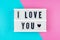 I Love You - text on a display lightbox on blue and pink