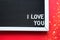 I love you in white letters on a framed blackboard. Whiteboard for entries and tags. Valentine`s Day, a declaration of love, a