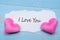 I LOVE YOU word on paper note with couple pink heart shape decoration on blue wooden table background. Wedding, Romantic and Happy